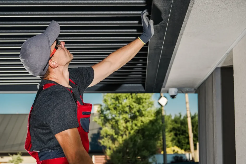 Skilled worker installing pergola louvres for Pergolas Christchurch with Fence Builders Christchurch.